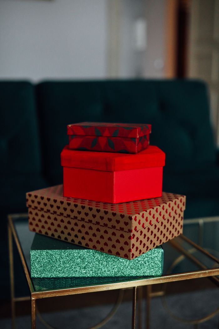 A vibrant stack of gift boxes on a glass table in a cozy living room setting.